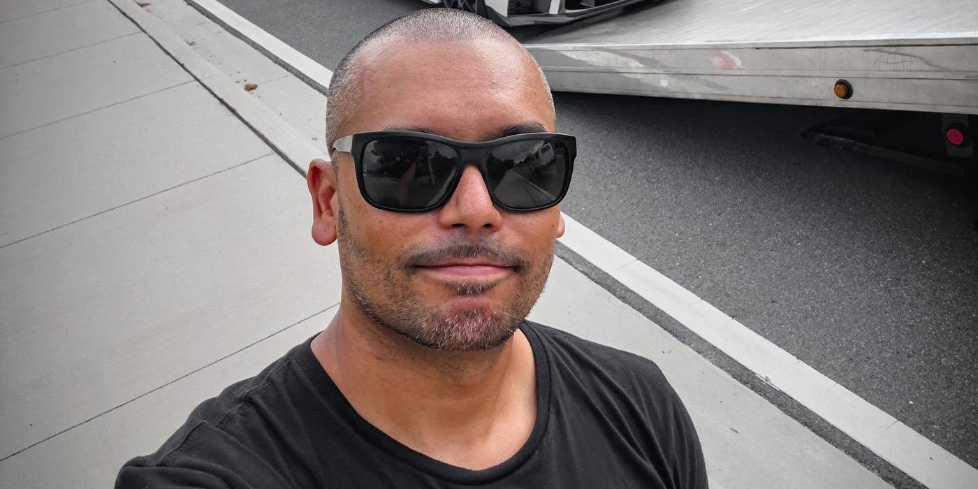 Randen Montalvo from Survivor 46 wears a black t-shirt and black sunglasses.
