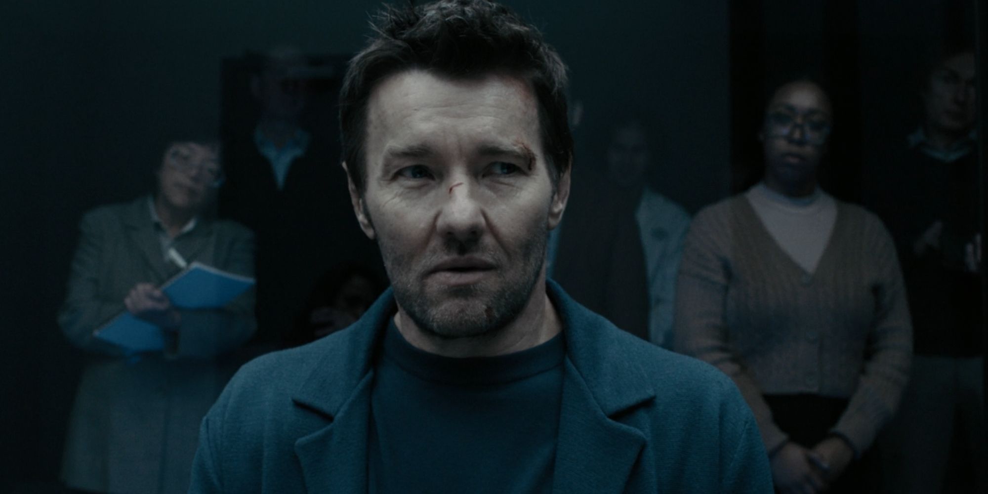 Joel Edgerton looking uneasy as Jason Dessen in Dark Matter as people watch on from behind glass