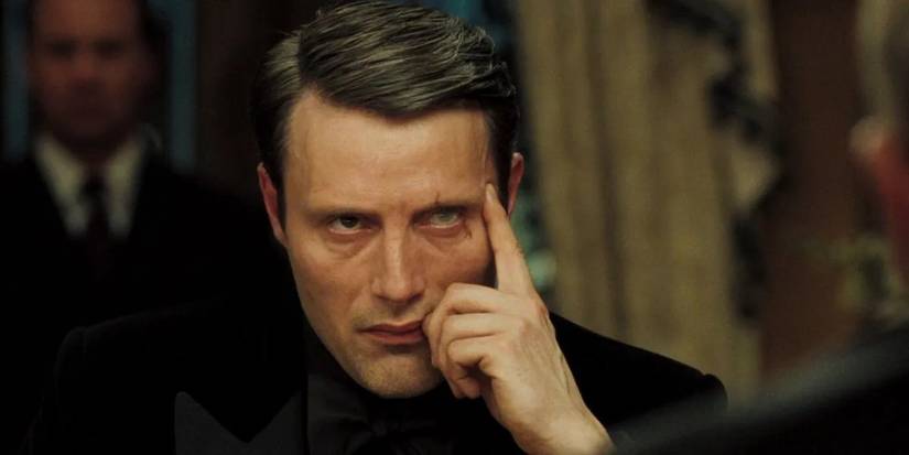 Mads Mikkelsen as Le Chiffre glowering and resting his hand on his face in Casino Royale