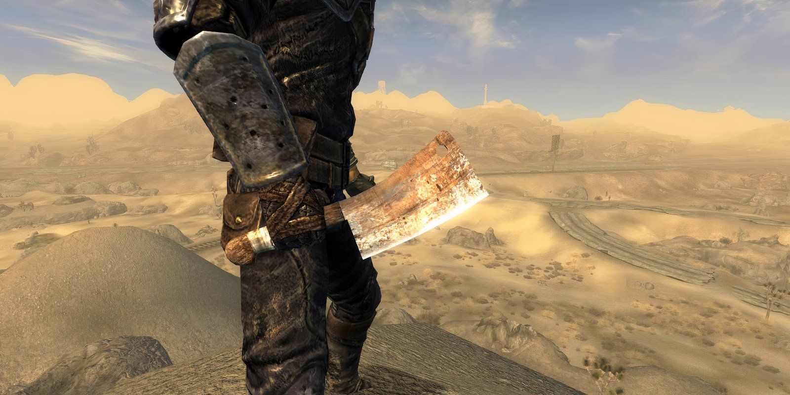 Um close de um cutelo na mão de um personagem do jogador, olhando para um vale de Mojave em uma captura de tela de Fallout New Vegas.