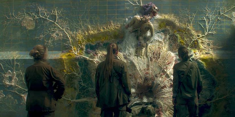 A mutated skeleton and fungi from Annihilation with three women staring at it.