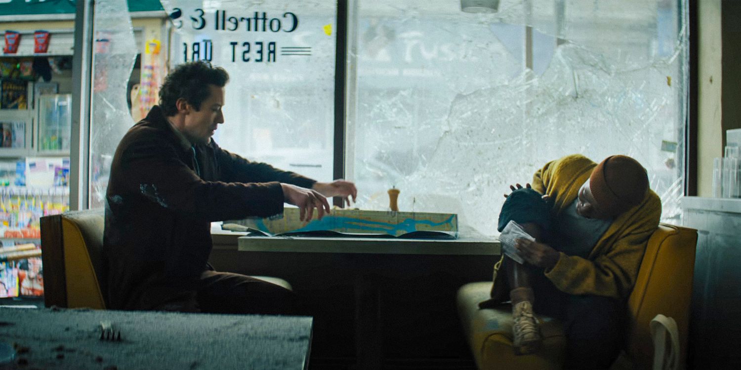 Sam (Lupita Nyong'o) cuida de um ferimento enquanto Eric (Joseph Quinn) olha um mapa em A Quiet Place: Day One