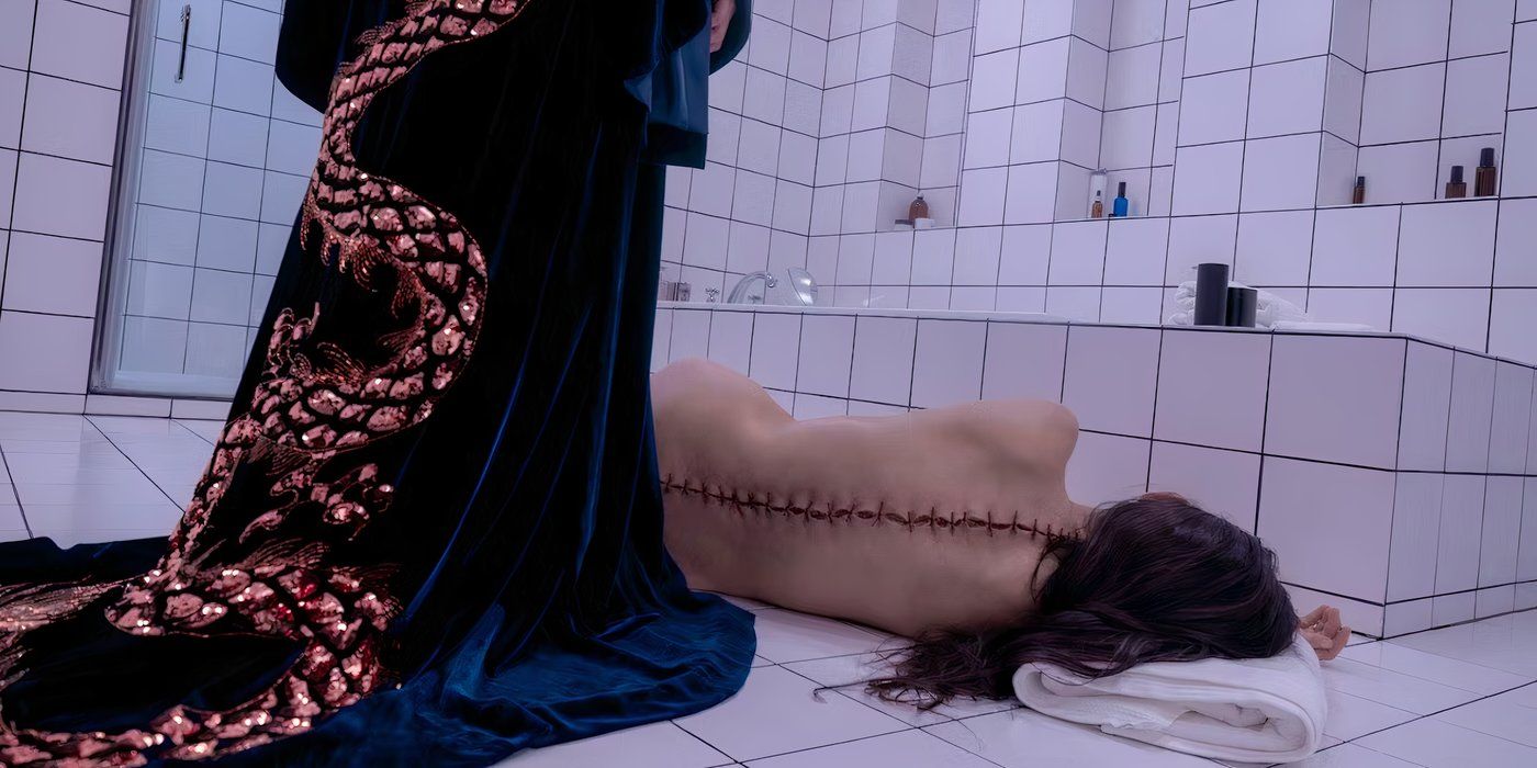 Uma mulher deitada no chão do banheiro com as costas costuradas na imagem do filme A Substância