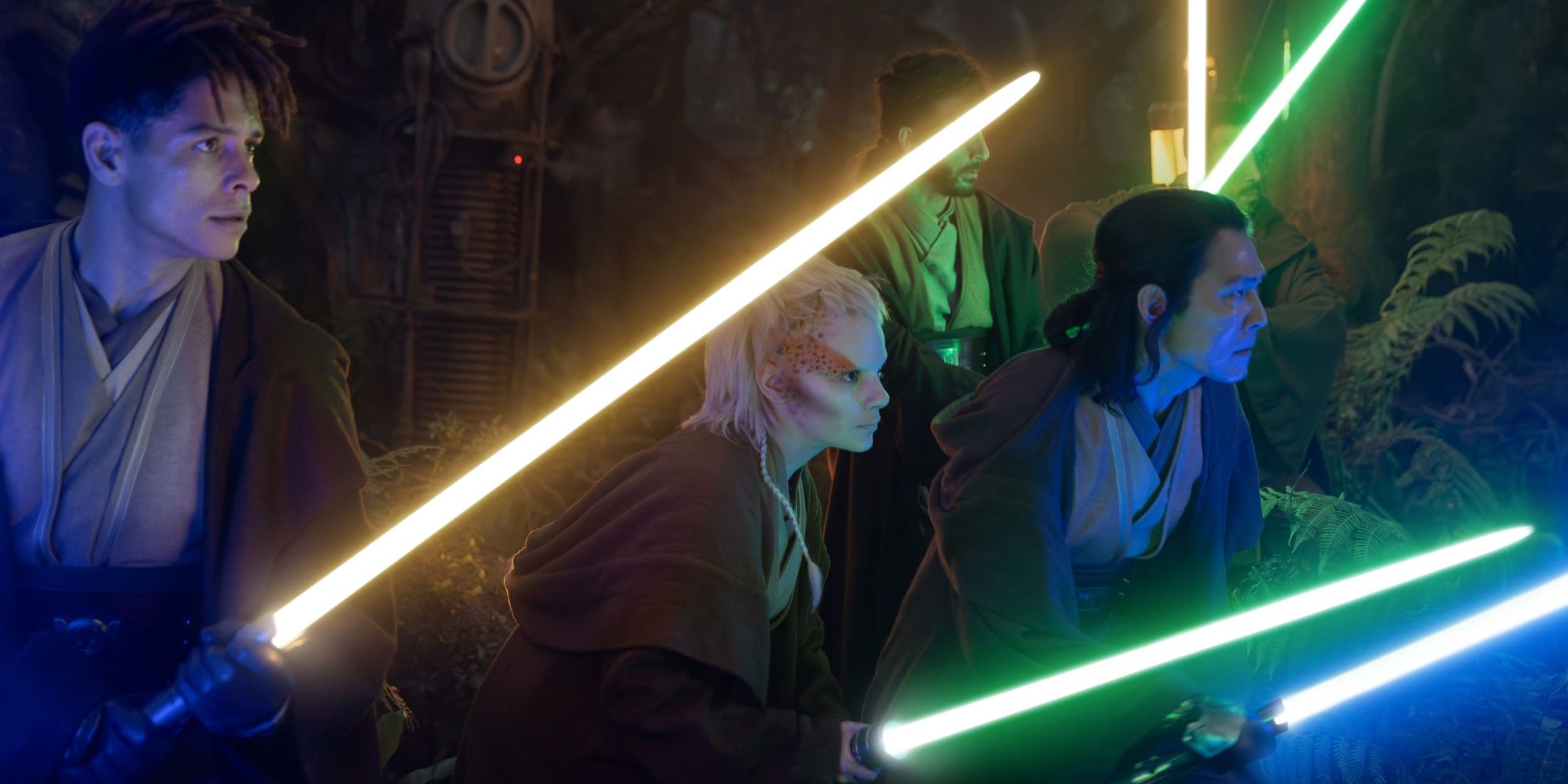Jedi Knight Yord Fandar, Padawan Jecki Lon, and Master Sol, along with others, brandish lightsabers in multiple different colors in a dark forest in Star Wars: The Acolyte