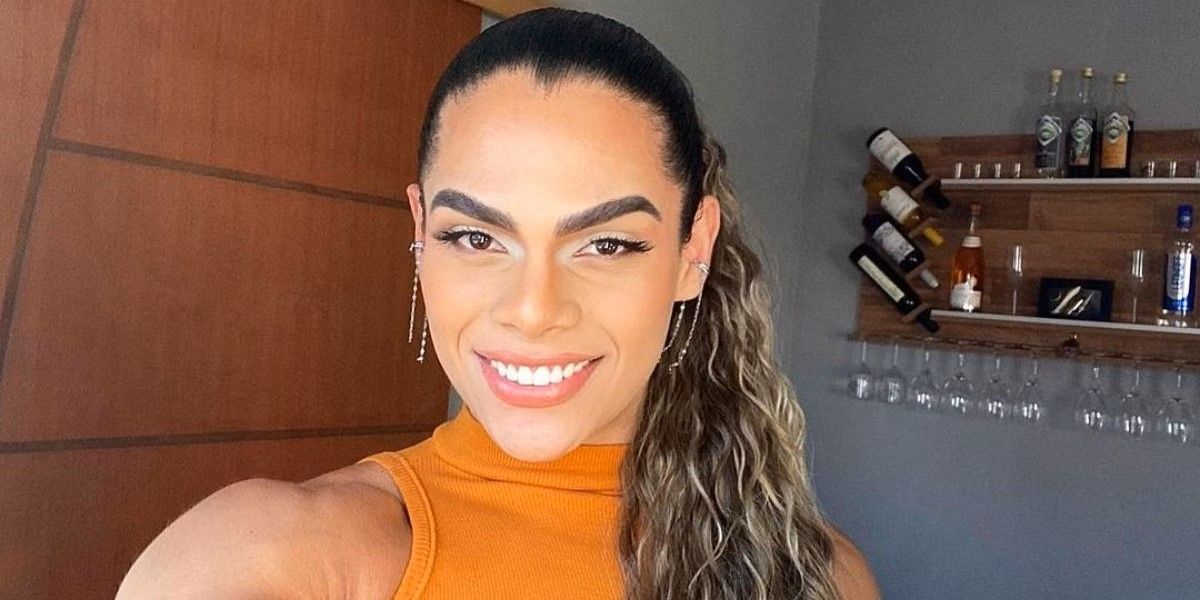 Alliya from 90 day fiance love in paradise smiles taking a selfie wearing an orange top