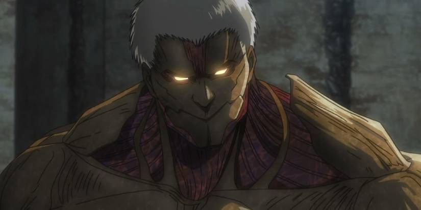 Attack on Titan's Armored Titan has glowing eyes as it looks down in thought.