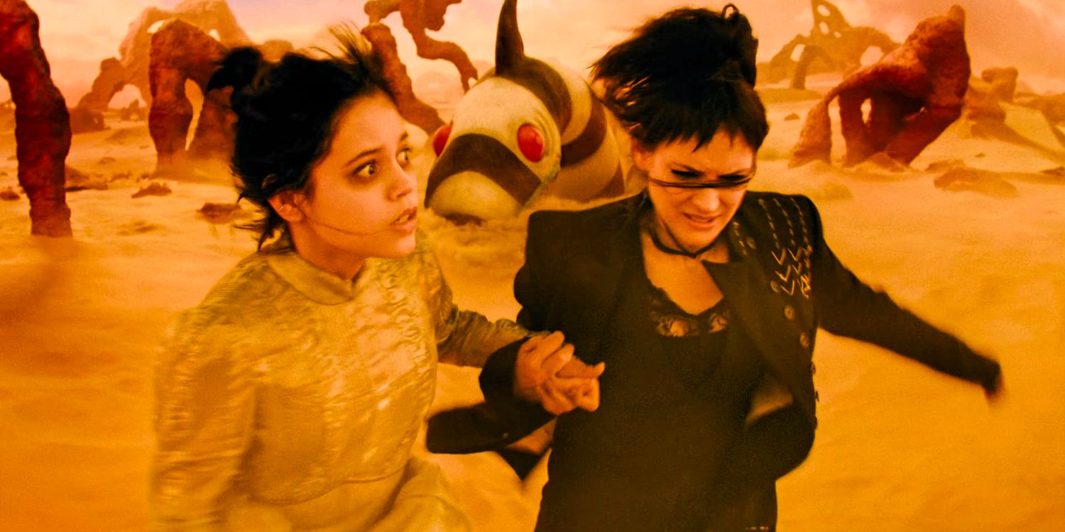 Astrid (Jenna Ortega) and Lydia Deetz (Winona Ryder) are running through the desert, trying to escape from a strange creature in Beetlejuice 2