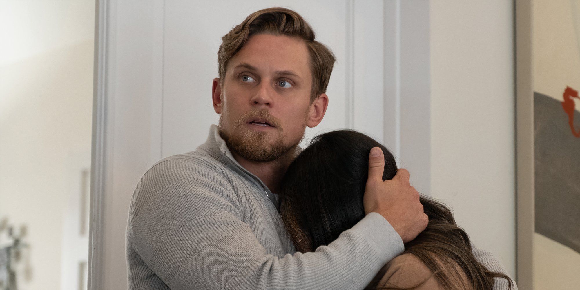 Billy Magnussen holding a woman's head to his chest in Reunion