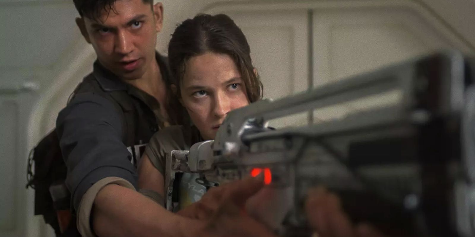 Cailee Spaeny and Archie Renault pointing guns at each other in Alien: Romulus