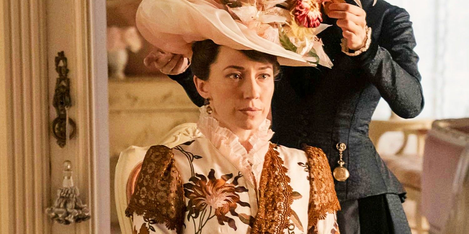 Carrie Coon as Bertha Russell sitting in front of a mirror as a maid adjusts her hat on The Gilded Age
