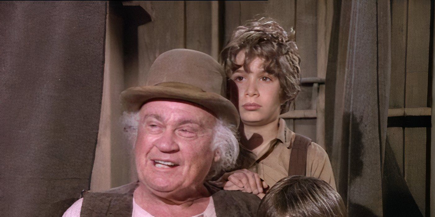 Dub Taylor como Houston Lamb sentado e conversando com o braço em volta de um menino e outro menino atrás dele em Little House on the Prairie.