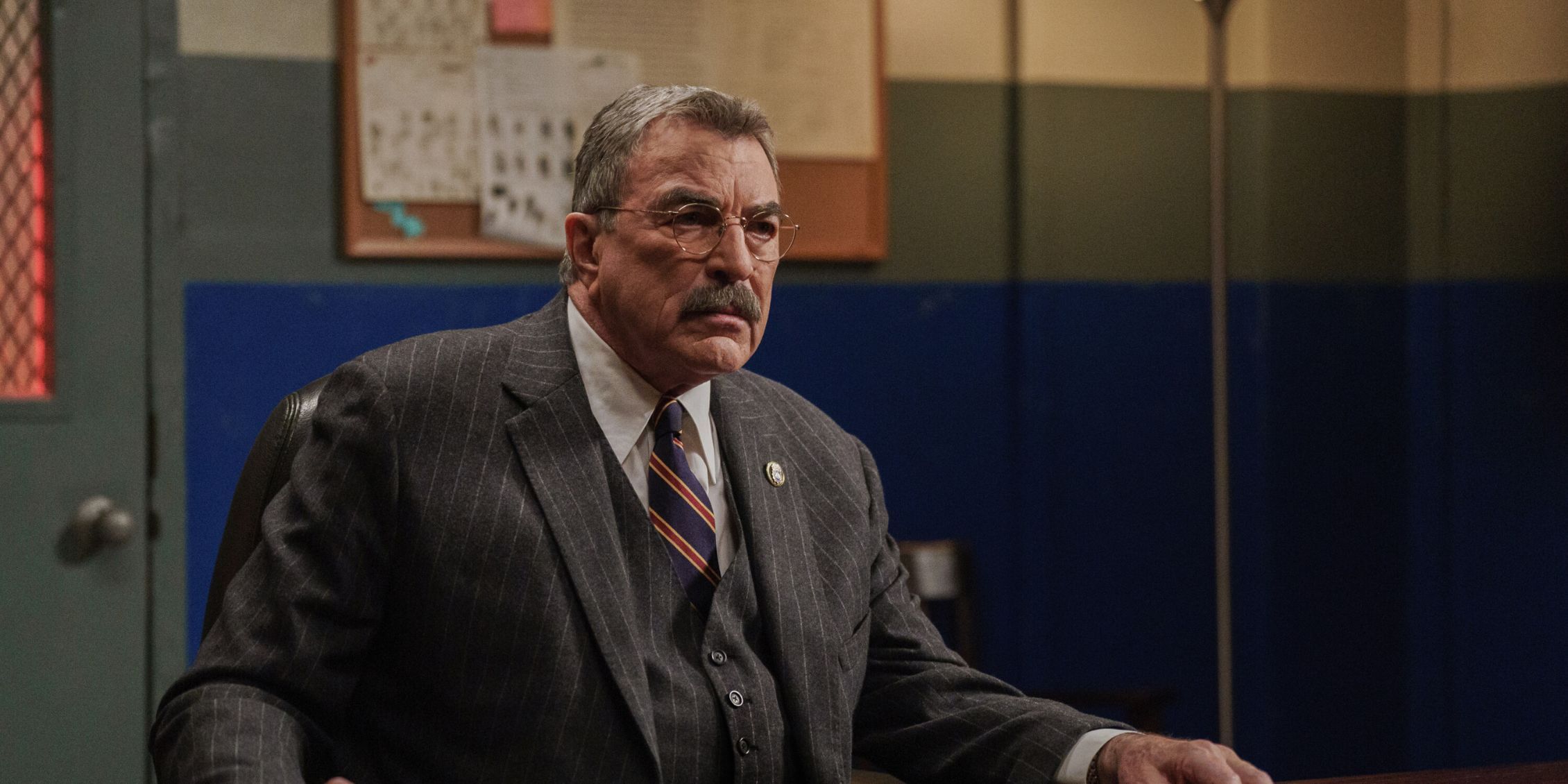 Tom Selleck as Commissioner Frank Reagan sitting behind a desk on Blue Bloods