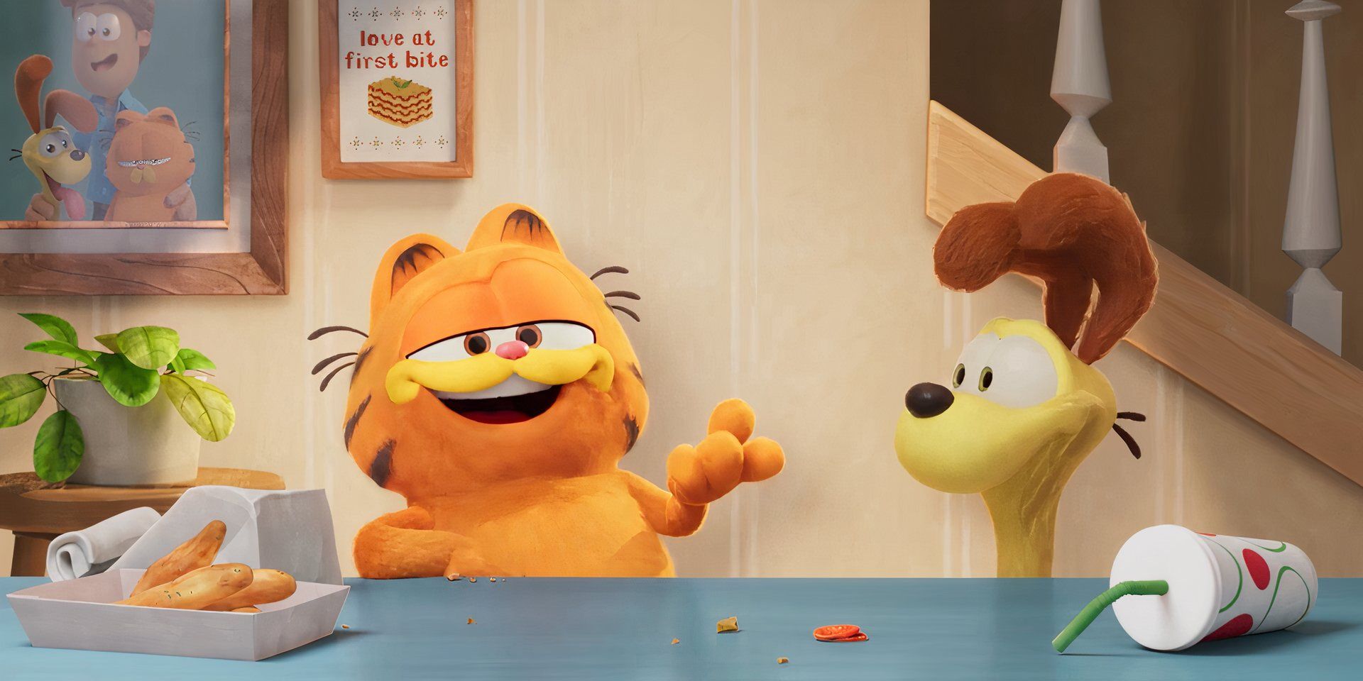 Garfield (voz de Chris Pratt) falando para a câmera enquanto Odie (Harvey Guillen) senta ao lado dele parecendo feliz em O Filme Garfield