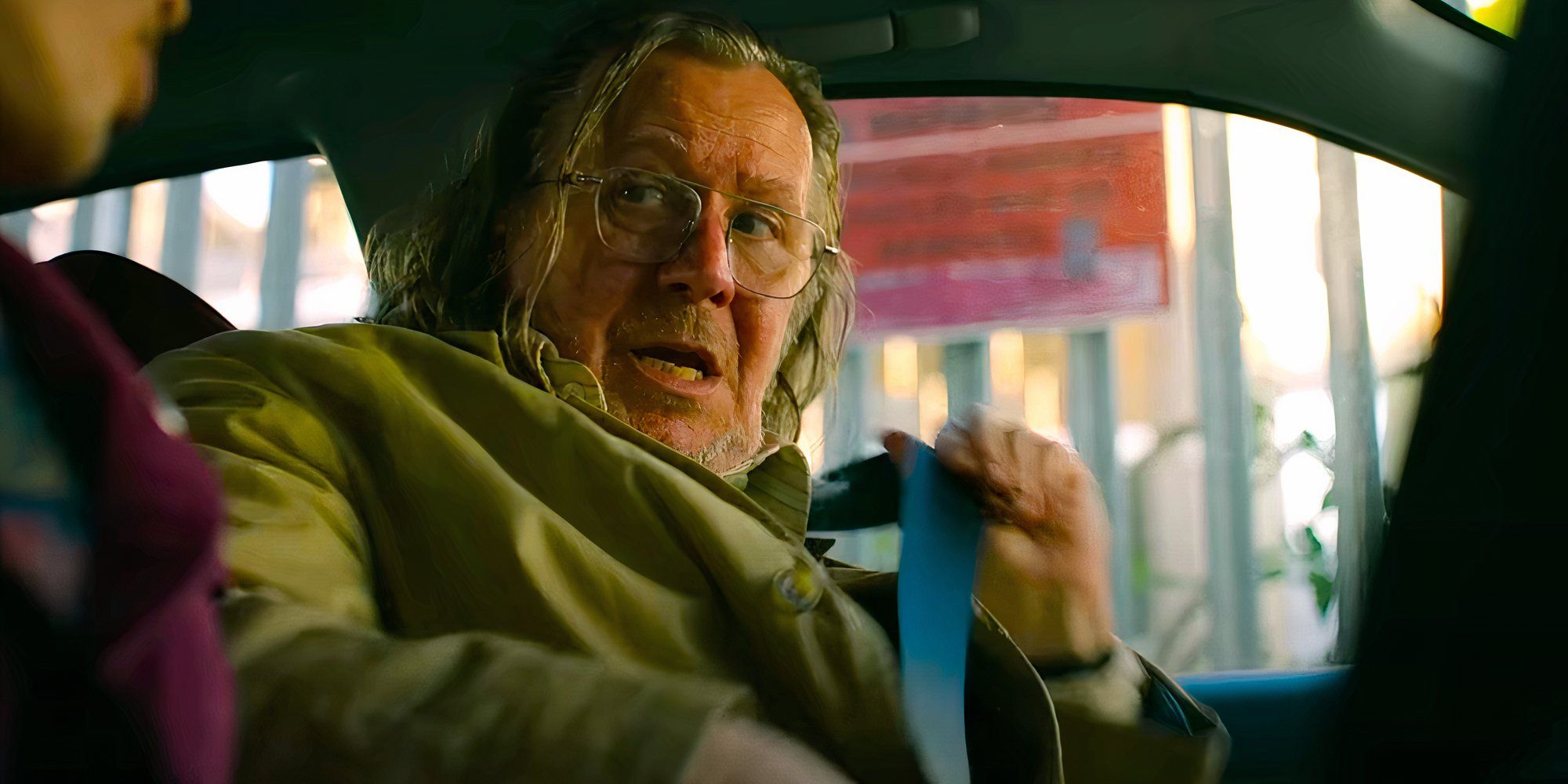 Gary Oldman talks while buckling his seatbelt in a scene from Slow Horses season 3