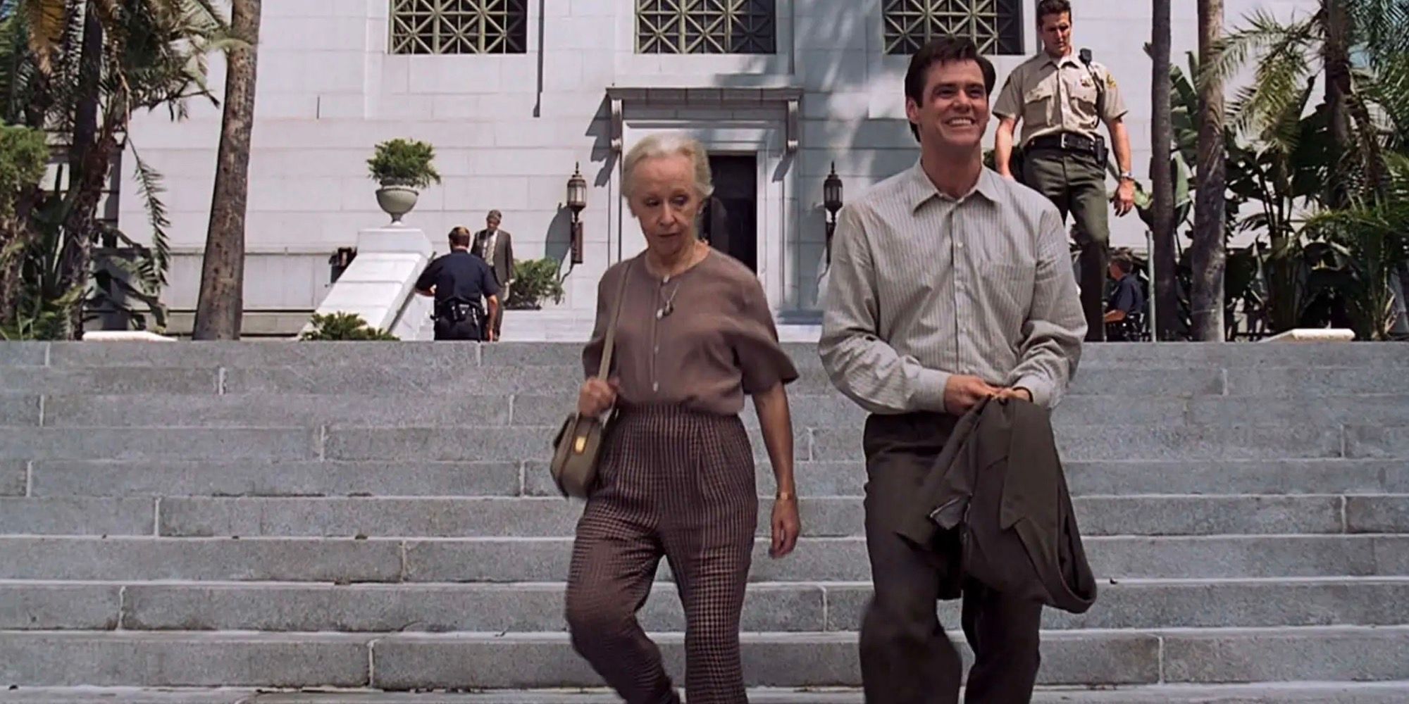 Anne Haney e Jim Carrey estão descendo as escadas. 