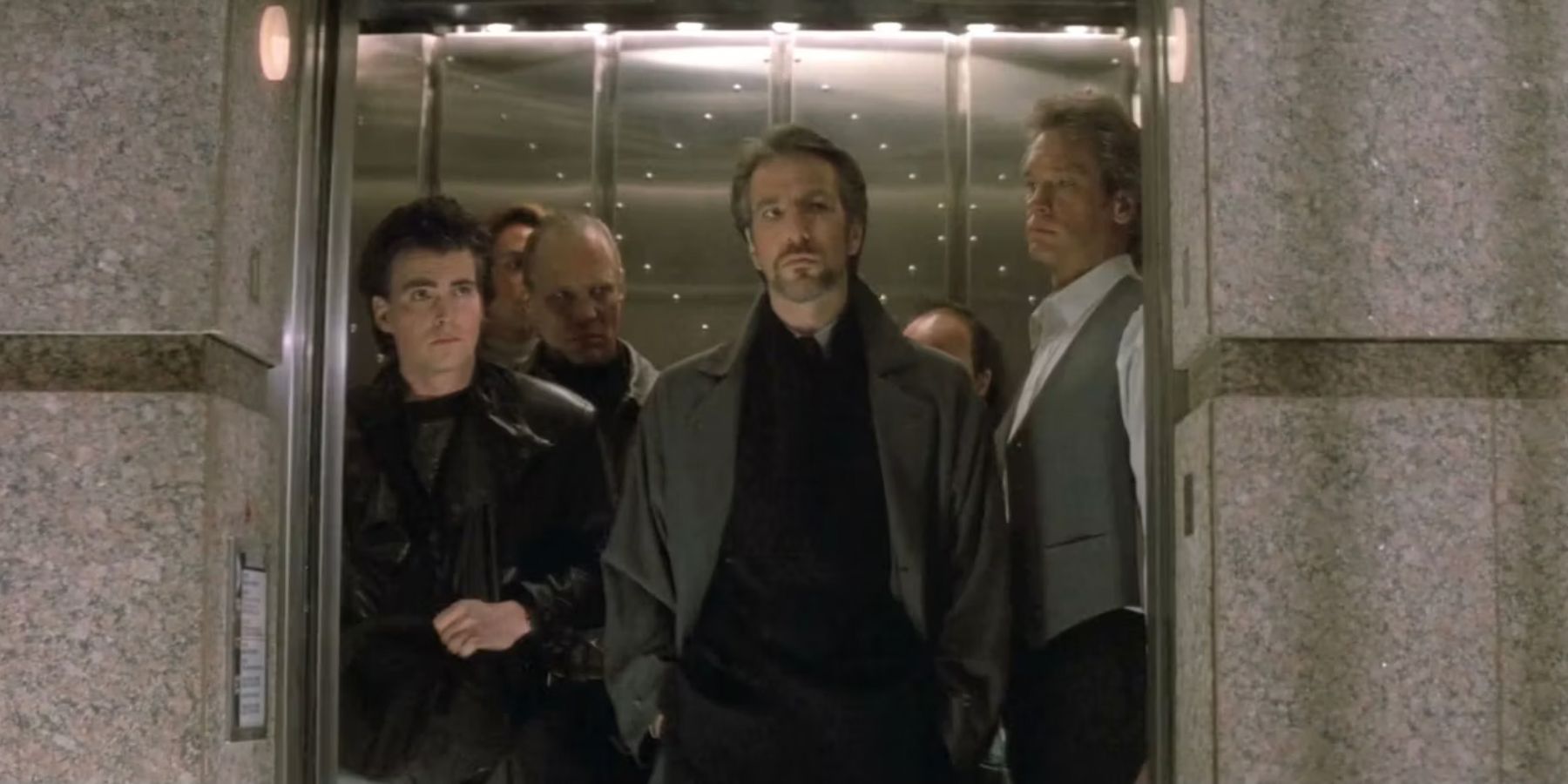 Hans Gruber at the front of an elevator full of his criminal team in Die Hard
