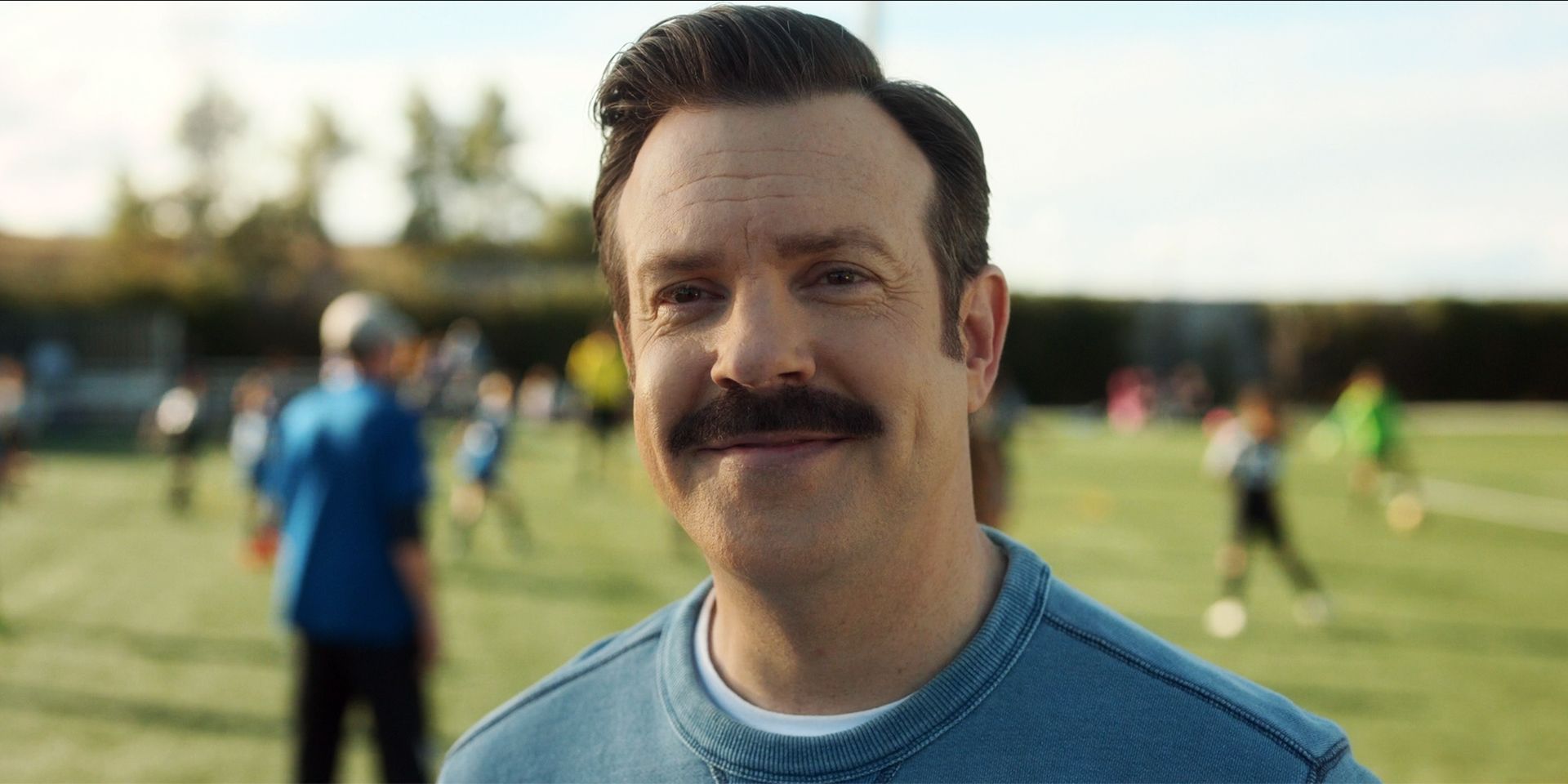 Jason Sudeikis as Ted Lasso smiling in a scene from Ted Lasso season 3, episode 12