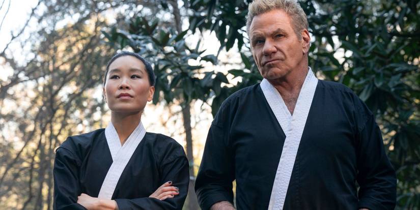 John (Martin Kove) and Kim (Alicia Hannah-Kim) Looking At Something In The Distance In Cobra Kai Season 6