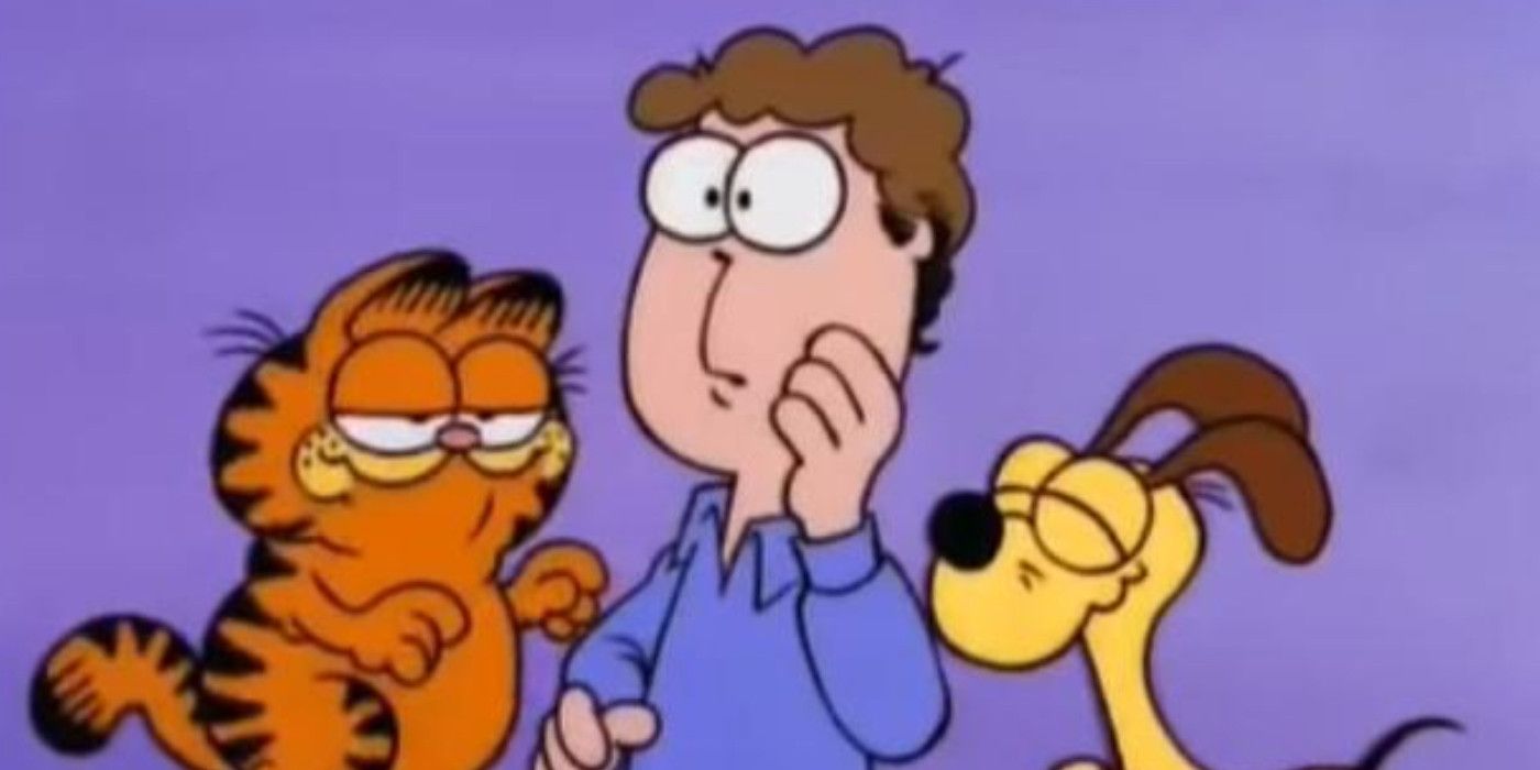 Jon, Garfield and Odie all together in an image from Here Comes Garfield, where Jon is wearing a blue shirt and looks concerned