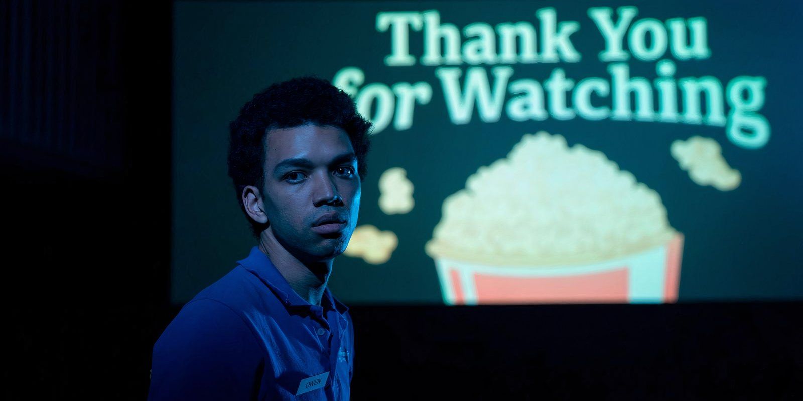 Justice Smith standing in front of a movie screen with the message 