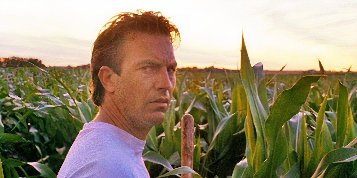Kevin Costner parado em um milharal com um olhar desconfiado em Campo dos Sonhos