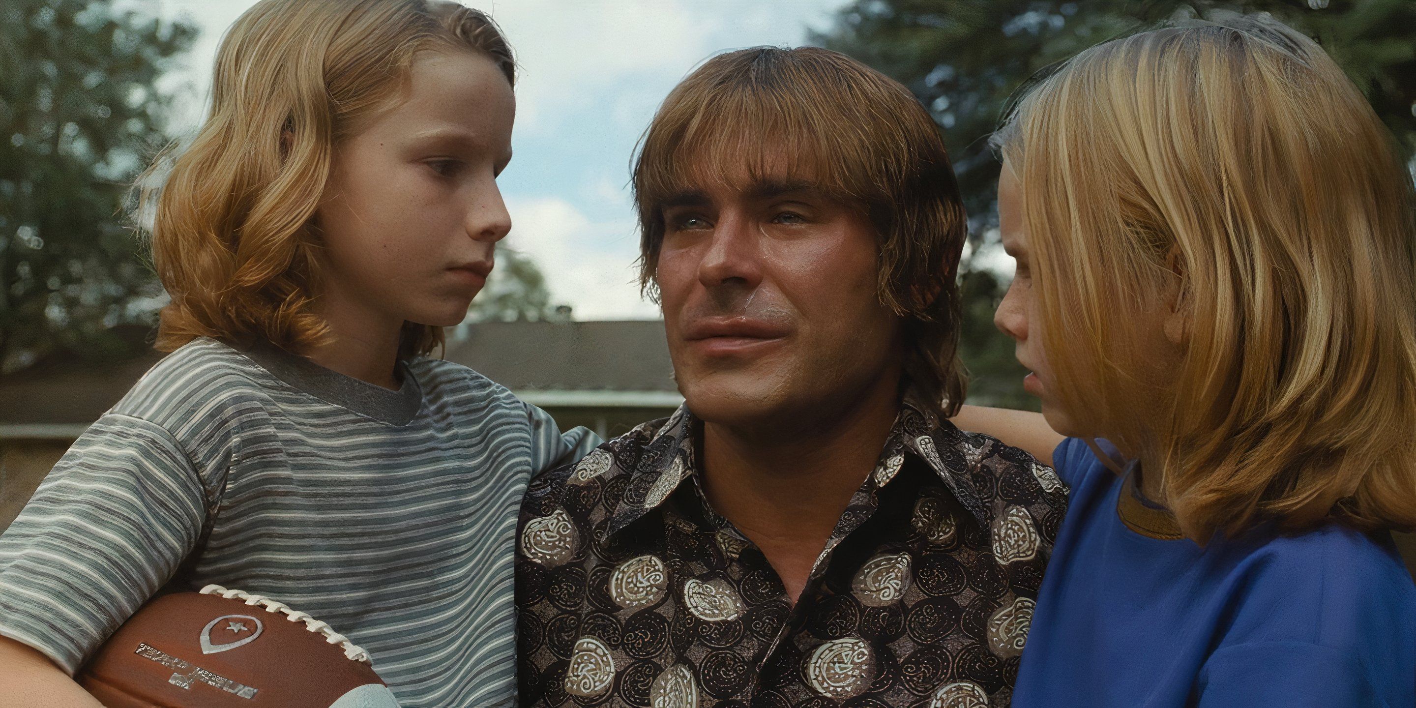 Kevin Von Erich (Zac Efron) chora abraçado aos filhos Ross (Leo Franich) e Marshall (Sam Franich) em A Garra de Ferro