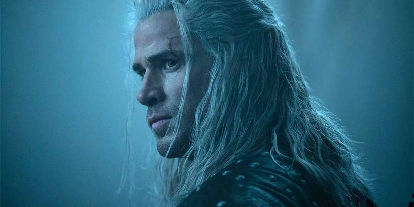 Liam Hemsworth as Geralt in The Witcher, sporting white hair and looking stoic