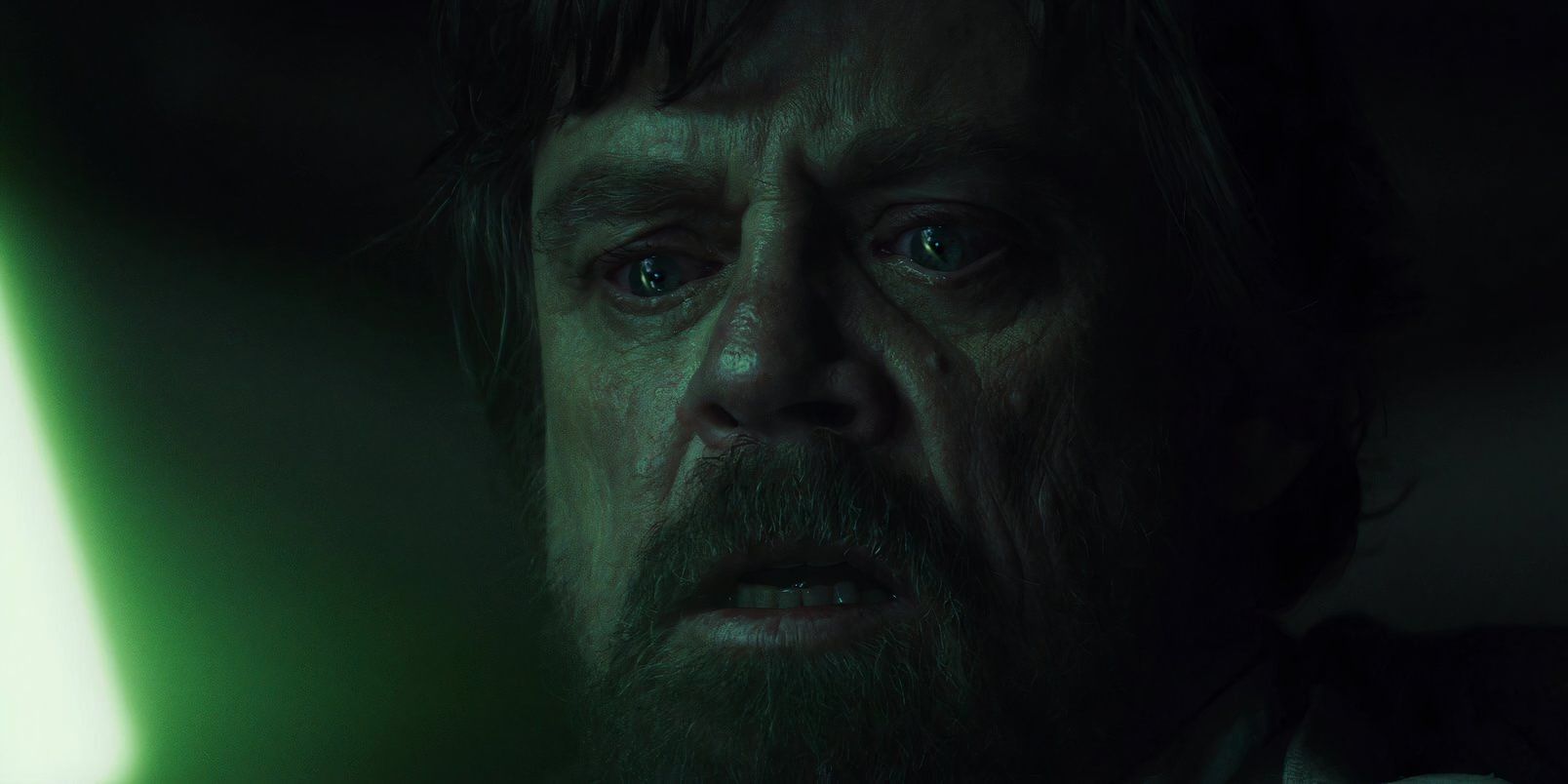 Luke Skywalker (Mark Hamill) looks down in horror at his green lightsaber with tears in his eyes after trying to kill Ben Solo in Star Wars: The Last Jedi