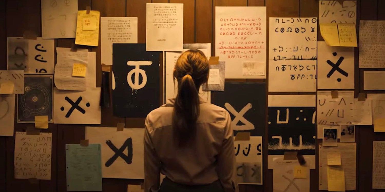 Maika Monroe as Lee Harker looking at a wall of symbols in Longlegs