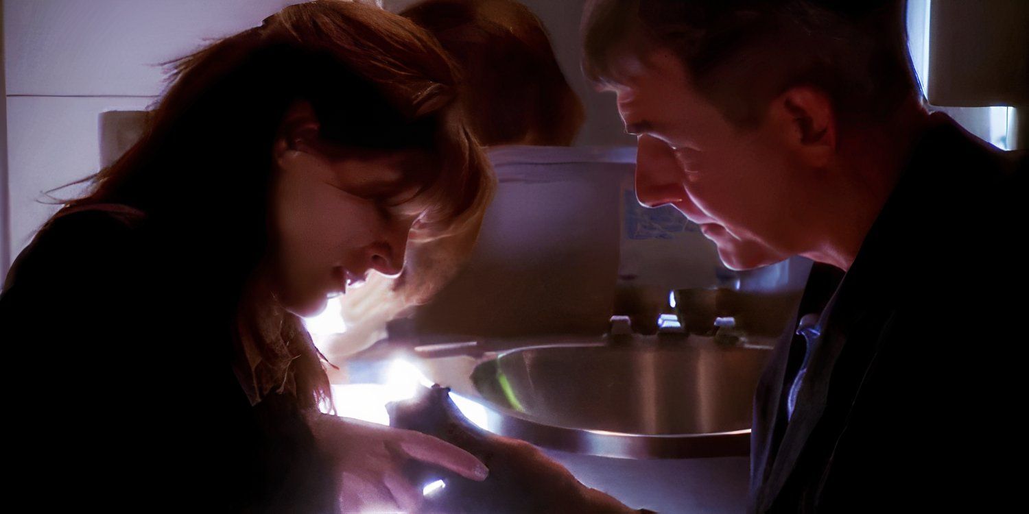 Mark Harmon as Gibbs handing a gun to Sasha Alexander as Caitlin in NCIS season 1