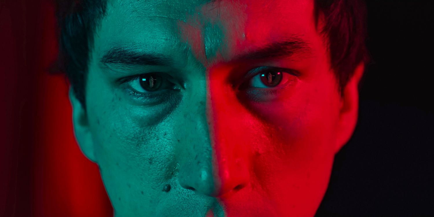 Close-up of Caesar Catalina (Adam Driver) with half of his face illuminated in red in Megalopolis