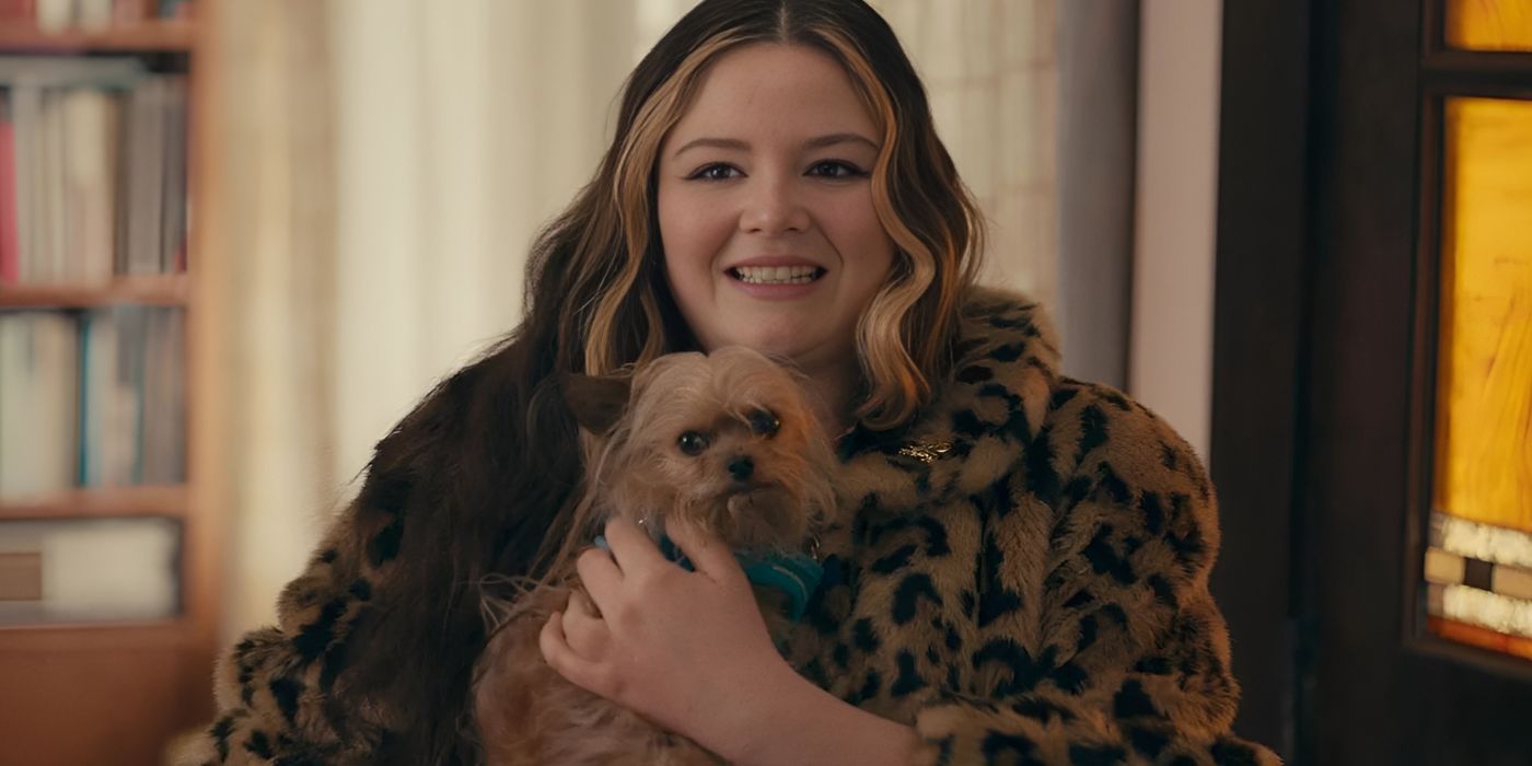 Megan Stalter as Cora grimacing while holding a small dog in Cora Bora