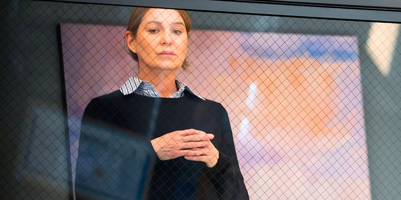 Meredith Grey (Ellen Pompeo) stands in the OR gallery looking thoughtful in the Grey's Anatomy season 20 finale