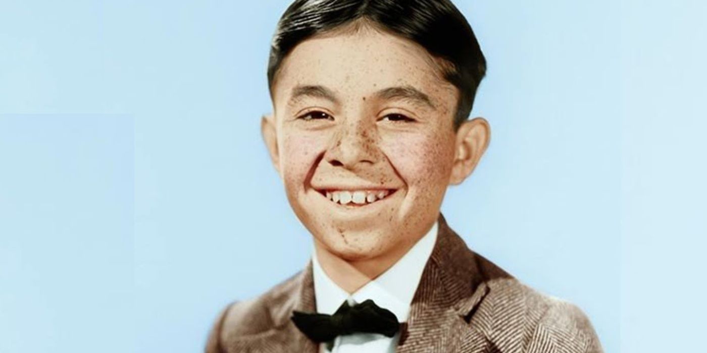 Alfalfa (Carl Switzer) smiling in a suit and bowtie in Our Gang