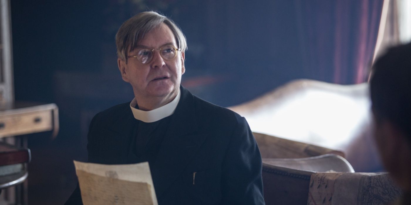 Rev. Wakefield holding old sheets of paper in Outlander