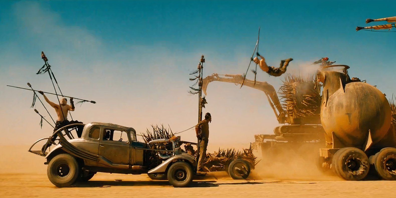 A Warboy jumps onto a spiked car next to Max and Nux's car in Mad Max: Fury Road