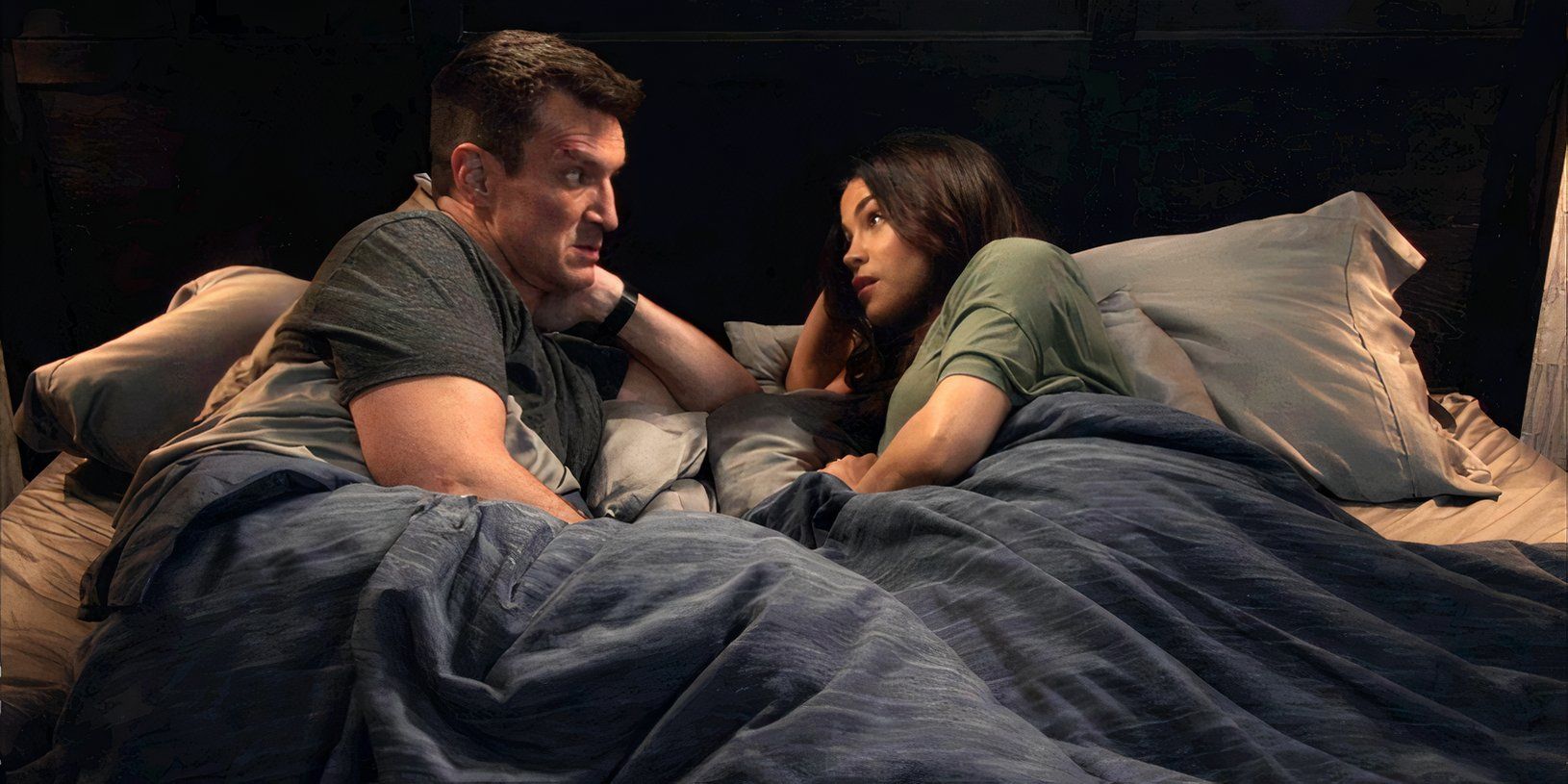 Nathan Fillion as John Nolan and Jenna Dewan as Bailey Nune in bed together in The Rookie season 6, episode 10