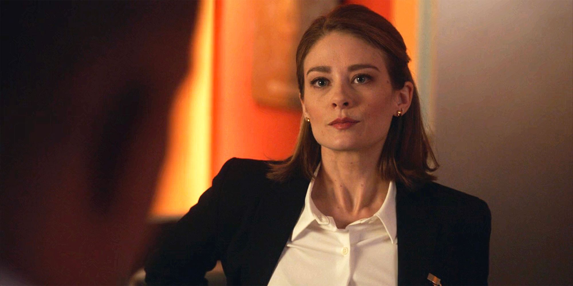 Agent Rose against a vibrant orange-painted wall at NCIS Headquarters