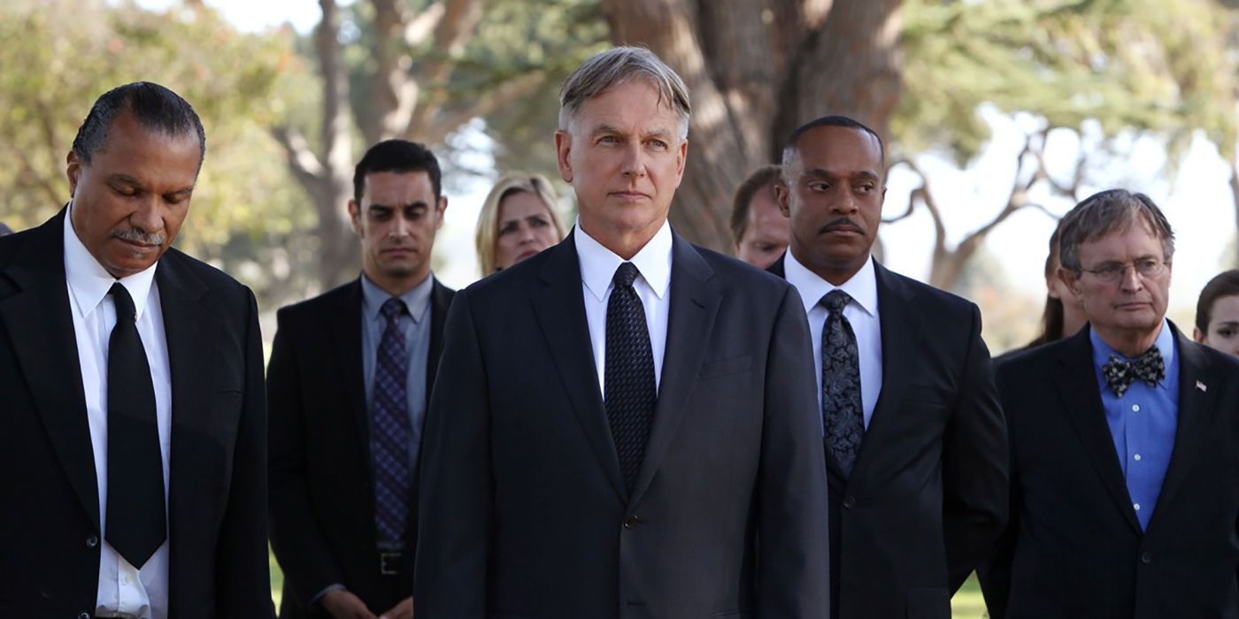 Leroy Gibbs, played by Mark Harmon, with his team at his father's funeral in NCIS. Team members Leon Vance and Donald 