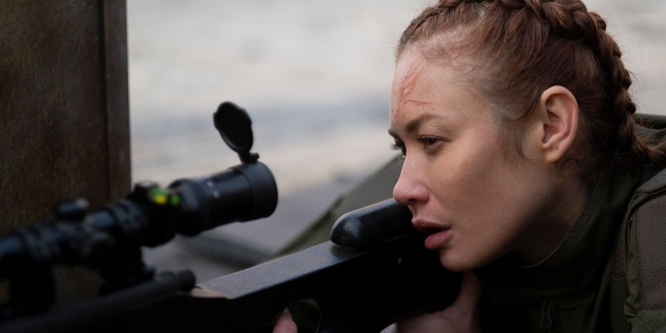 Olga Kurylenko as Krystyna aiming through a sniper rifle in Chief of Station