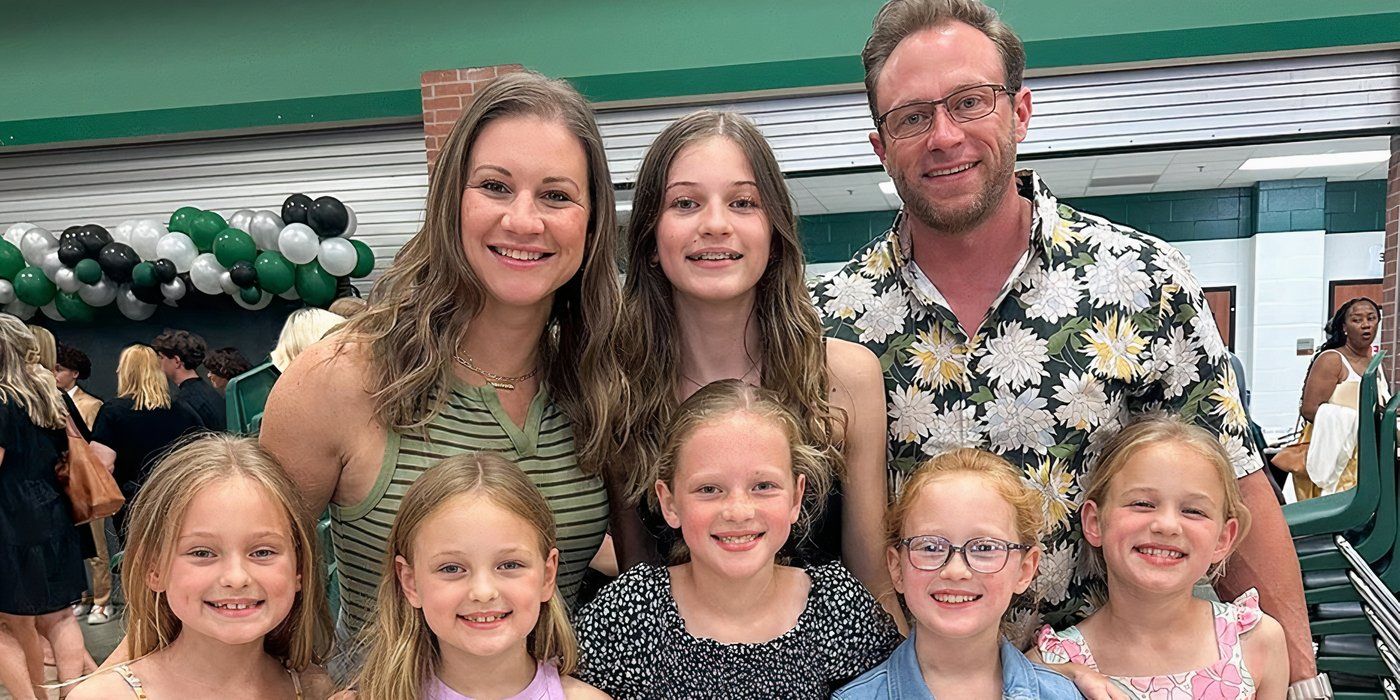 Outdaughtered The Busby family taking a photo with green, black and white balloons in the background