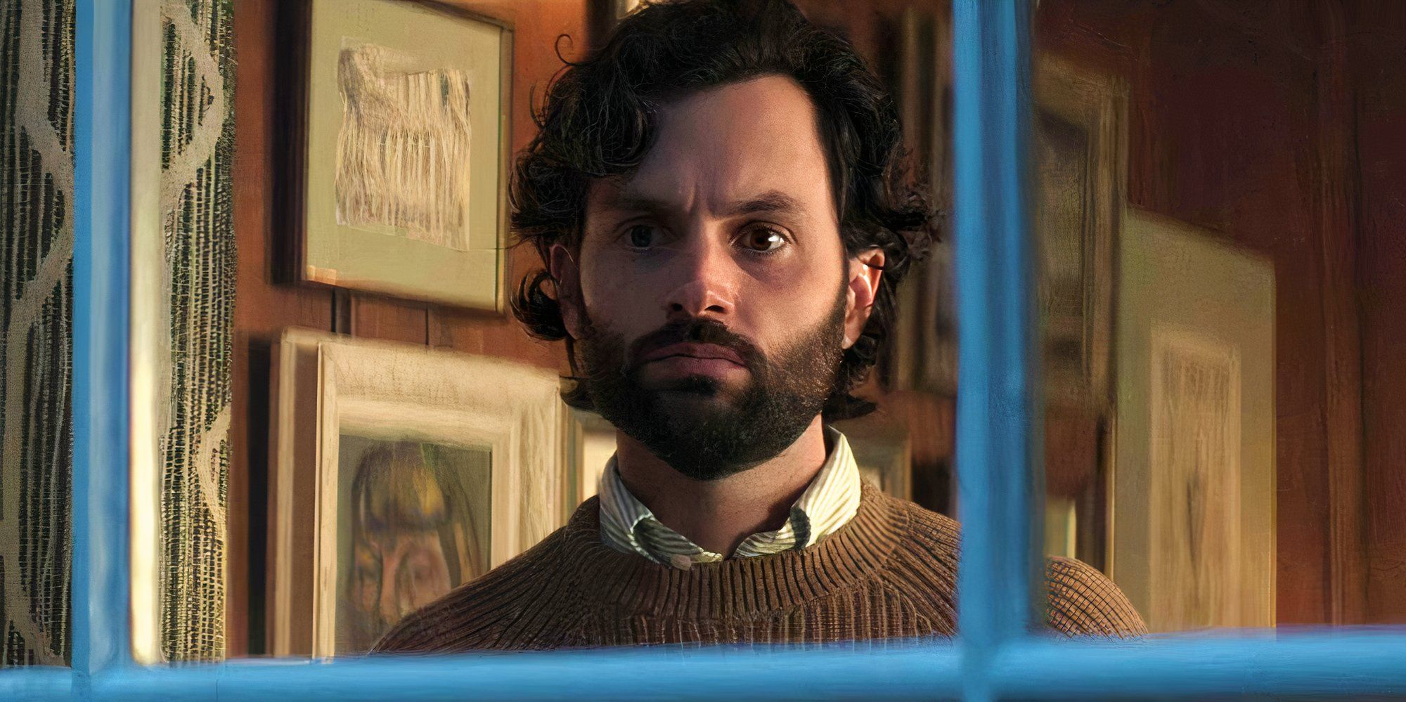 Penn Badgley as Joe Goldberg looking out of a window in You