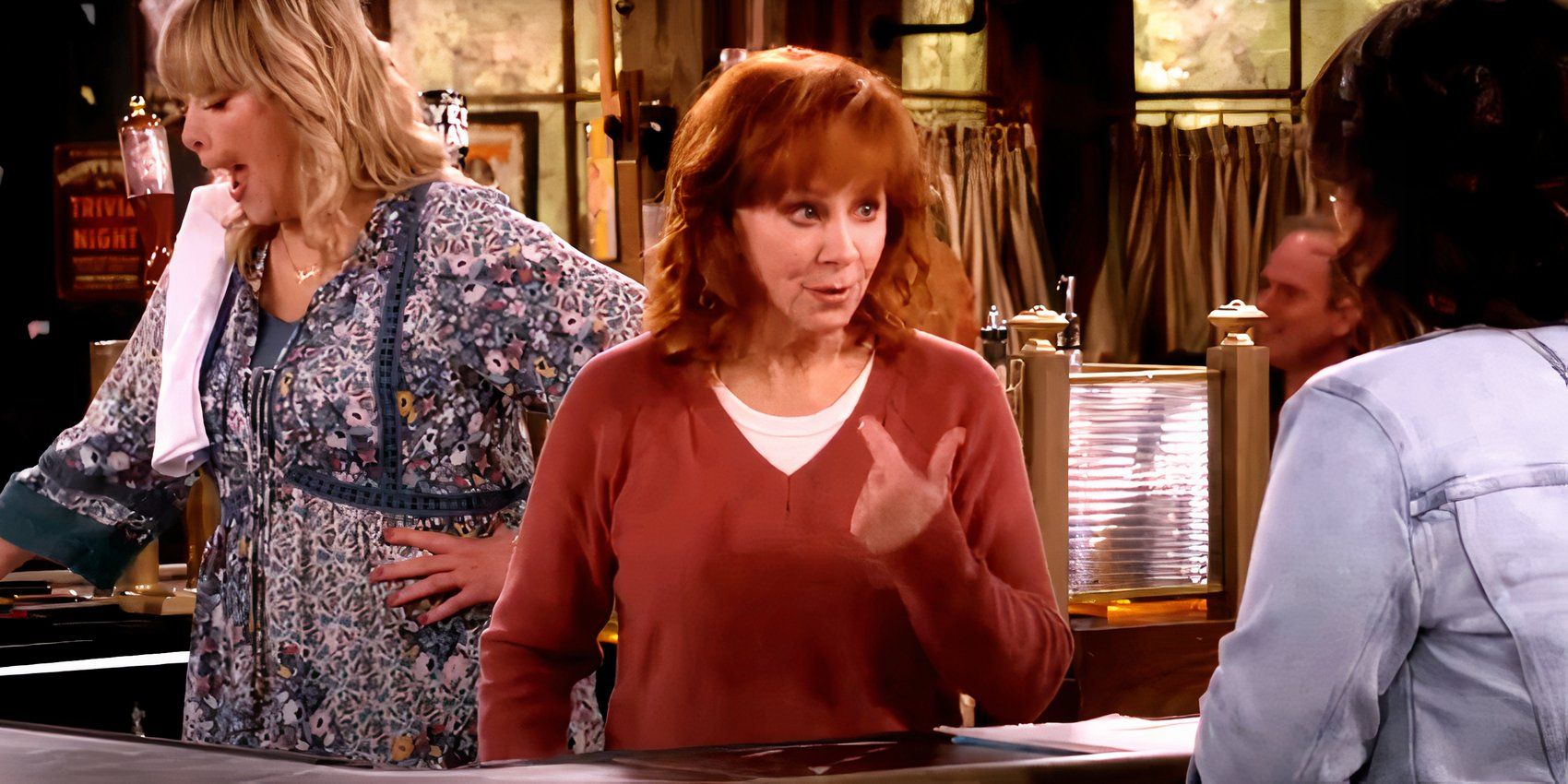 Reba points the finger at herself while at the bar in Happy's Place