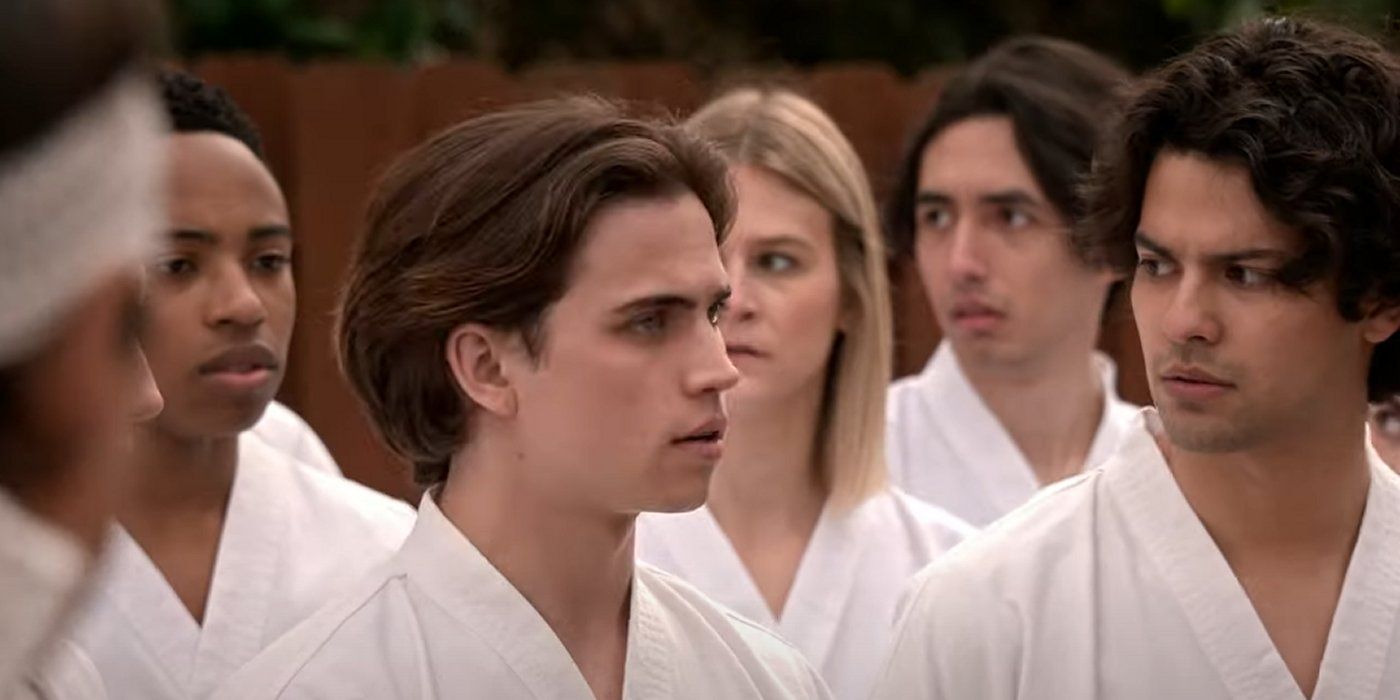 Miguel, Robby, and Kenny wearing white karategi and looking concerned in Cobra Kai season 6