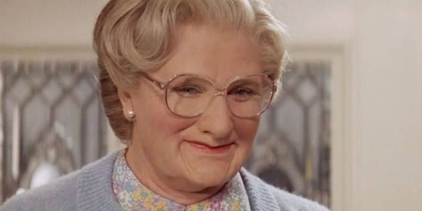 Robin Williams smiling as Mrs. Doubtfire in the full Mrs. Doubtfire costume
