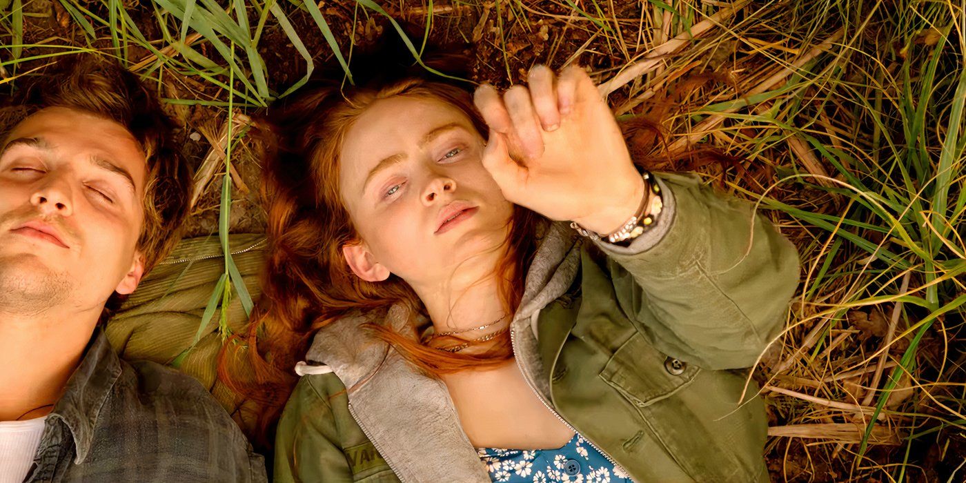 Sadie Sink as Mazzy Lying in the Grass While Holding Her Hand Up In A Sacrifice