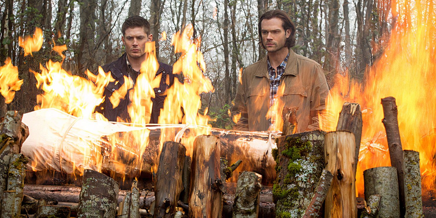 Sam (Jared Padalecki) and Dean Winchester (Jensen Ackles) watch a body burning in the woods in Supernatural