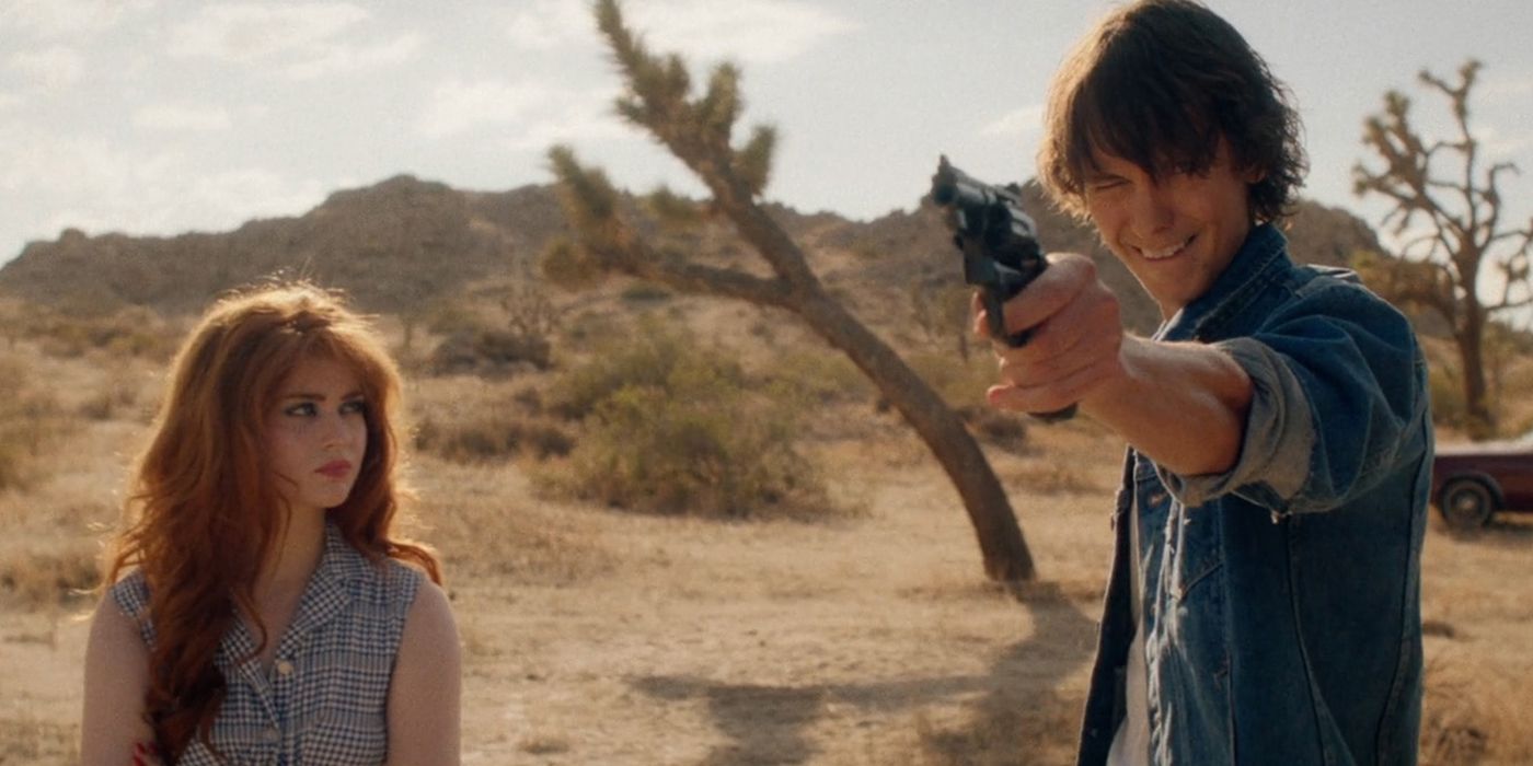 Sierra McCormick como Sybil olhando para Miles apontando uma arma em The Last Stop in Yuma County