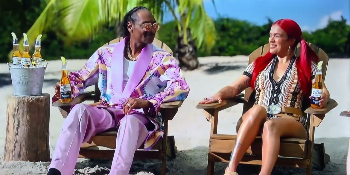 Snoop Dogg and Karol G hanging out on the beach and drinking beers in a Corona commercial.