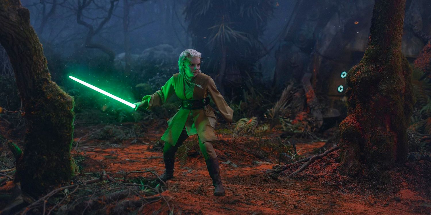 Jedi Padawan Jecki Lon brandishes her green lightsaber in a dark forest in Star Wars: The Acolyte